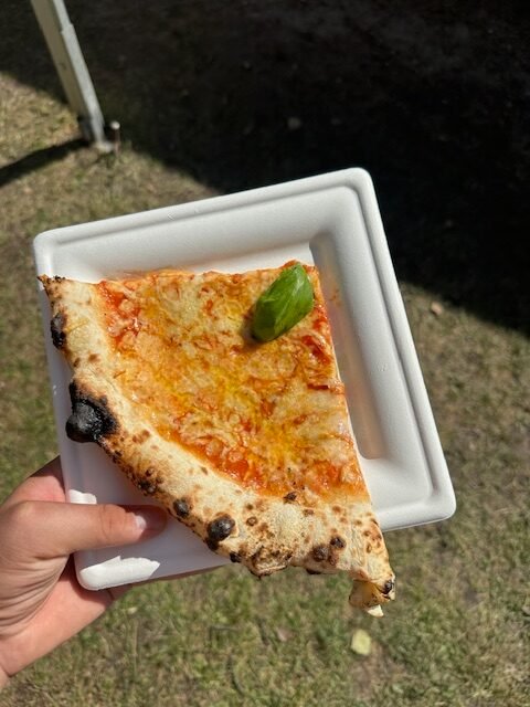 Pizza lautasella, jonka täytteet ovat: Tomaattikastike, Mozzarella, Untamonloukon Savujuustua, tuore basilika sekä valkosipuli-oliiviöljy. Vääksyssä pizzafestareilla otettu kuva pizzasta.